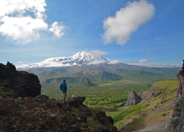 Wanderer blickt auf den Vulkan Tolbacik im Tal der Vulkane